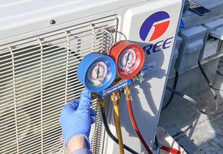 Montreal, Canada - May 24, 2020: Engineer checking AC refrigerant level and refilling freon. Gree Electric is a partially state-owned Chinese appliance manufacturerのeditorial素材
