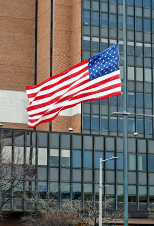 waving American flag in Philadelphia over a building backgroundの写真素材