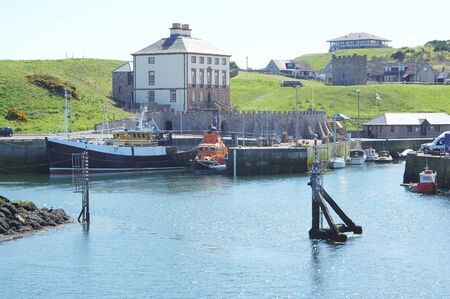 view of Eyemouth harbour with fishing boats and Lifeboat with Old Customs House behindの写真素材