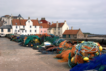 fishing nets, buoys and houses at harbour at Pittenweem, Fifeの写真素材