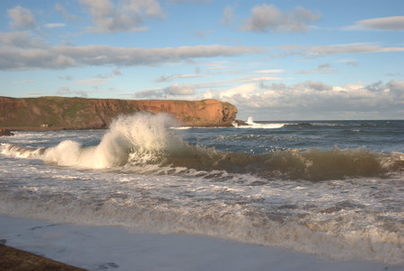 winter waves, cliffs and coast at Eyemouth, Berwickshireの写真素材