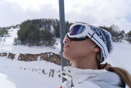 Portrait of beautiful skier in ski lift looking at skyの写真素材