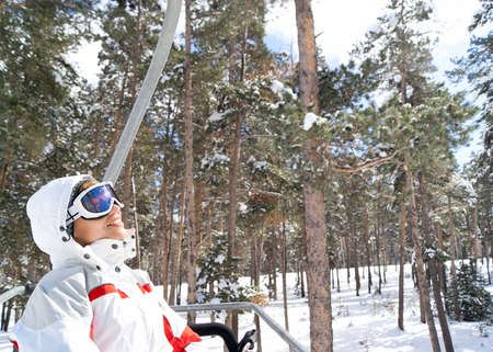 Beautiful skier going on chairlift in forest. Sarikamis. Turkeyの写真素材