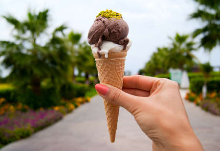 Ice cream cone with two scoops in woman hand の写真素材