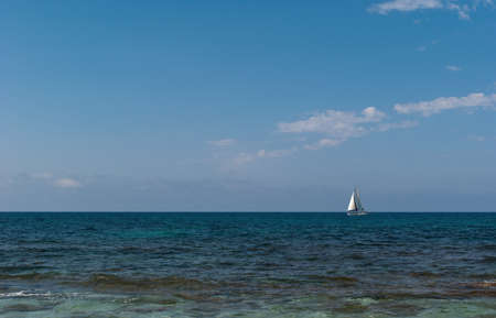 White sailboat sail colorful Mediterranean sea on the horizonの写真素材
