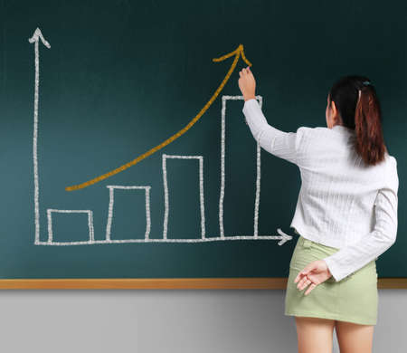 Business woman showing charts on the blackboardの写真素材