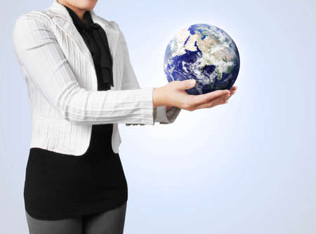 woman holding a globe in her handの写真素材