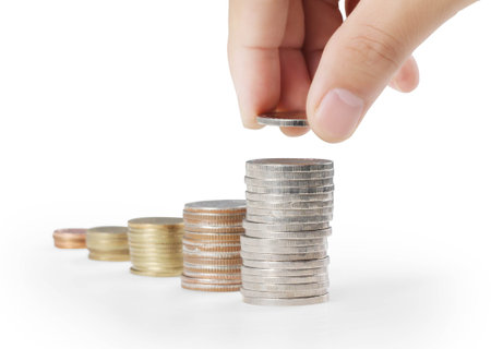 businessman hand coins in finger and row stacks them isolated on white