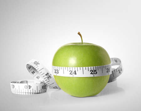 Green apples measured the meter on a white の写真素材