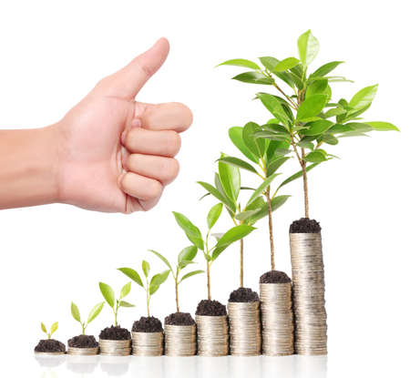 Businessman holding plant sprouting from a handful of coins の写真素材