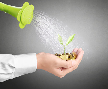 watering can pouring molten gold the gold coins の写真素材