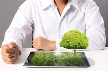 tablet computer with grass field and tree on it