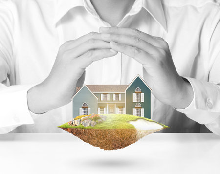 Hands Holding house representing home ownership and the Real Estate businessの写真素材