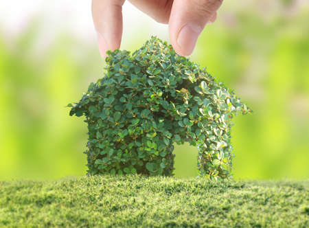 holding house representing home ownership and the Real Estate businessの写真素材