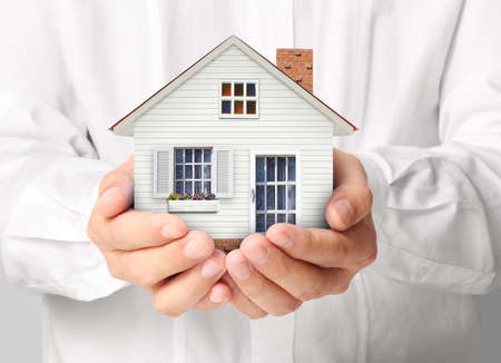 holding house representing home ownership and the Real Estate business holding house representing home ownership and the Real Estate business