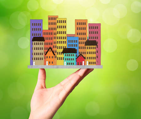 holding house representing home ownership and the Real Estate businessの写真素材