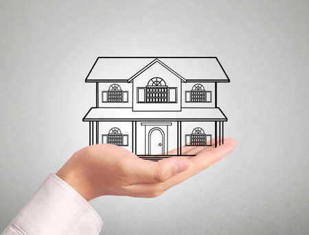 holding house representing home ownership and the Real Estate businessの写真素材