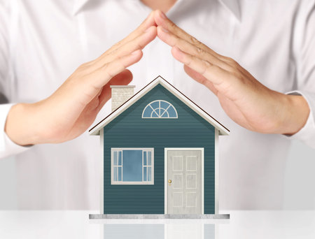 holding house representing home ownership and the Real Estate businesの写真素材