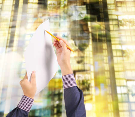 Hand holding white a blank paper sheetの写真素材