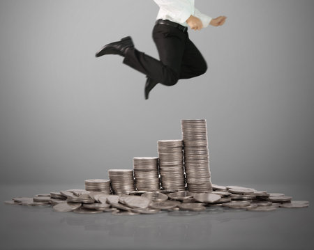 Businessman Jump on stack of coins which grows success and investment ...