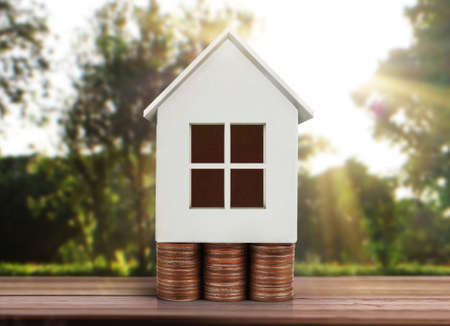 Small house standing on stacks of coinsの写真素材