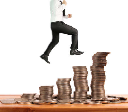 Businessman walk on stack of coins which grows success and investmentの写真素材