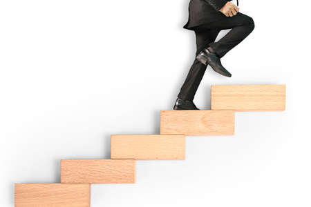 business person stepping up a toy staircaseの写真素材