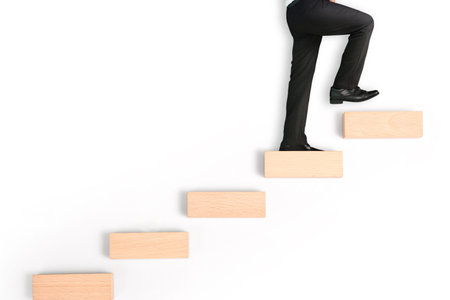 business person stepping up a toy staircase