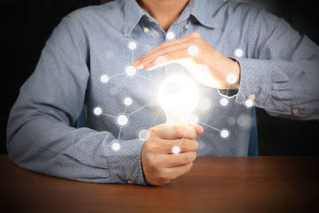 hand holding a light bulb with energy の写真素材