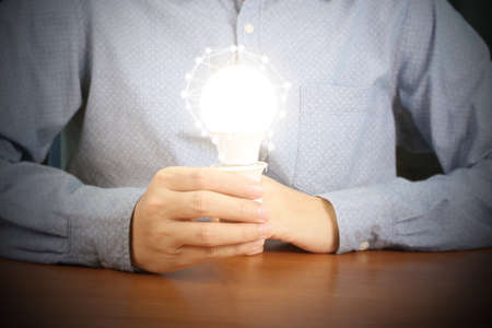 hand holding a light bulb with energy の写真素材