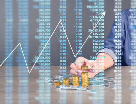 human hand putting coin to money, business ideasの写真素材