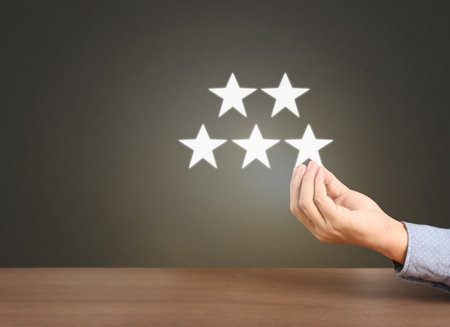 Hand touching five star symbol to increase rating of company concept