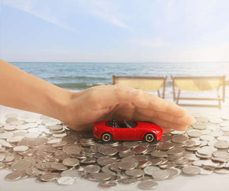 Car and house model with stack of a coins in  a handの写真素材