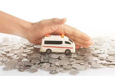 Car and house model with stack of a coins in  a handの写真素材