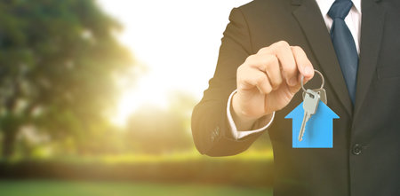 Hand holding house key, real estate agent,homeの写真素材