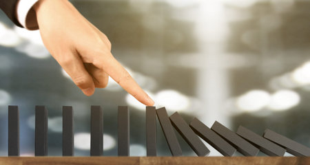 Hand stopping the Domino effect stopped by unique