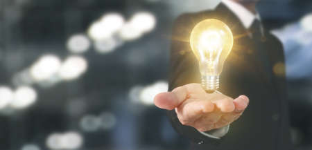 Hand of holding illuminated light bulb, idea, innovation inspiration conceptの写真素材