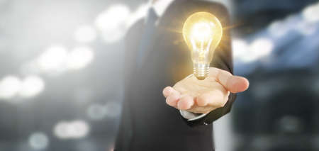 Hand of holding illuminated light bulb, idea, innovation inspiration conceptの写真素材