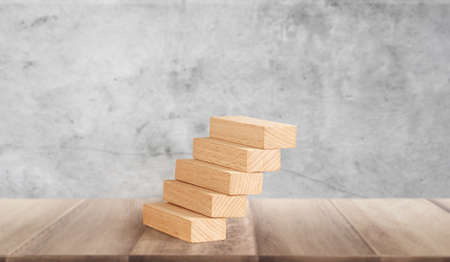 Hand liken person stepping up wood block stacking as step stair, business ideaの写真素材