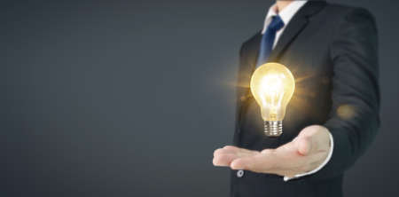 Hand of holding illuminated light bulb, innovation inspiration concept ,business ideaの写真素材