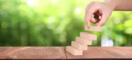 Wood block in hand stacking as step stair. Business concept growth success