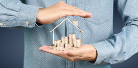 Growing coins house on stack coins in hand. Concept of Investment propert and finance investment...
