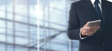 Man hand holding a smartphone device and touching screenの写真素材