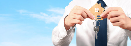 Real estate agent handing over house keys in a hand