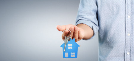 Real estate agent handing over house keys in a hand