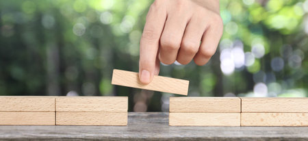 Hand placing a wooden block, Planning of project management in business