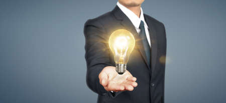 Hand of holding illuminated light bulb. idea innovation inspiration conceptの写真素材