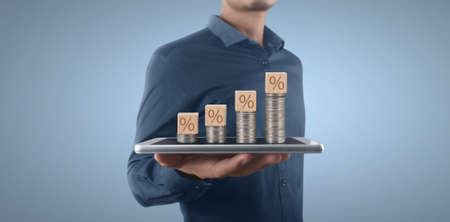 Coin and wealth concept. Loads of money on glass representing smartphoneの写真素材