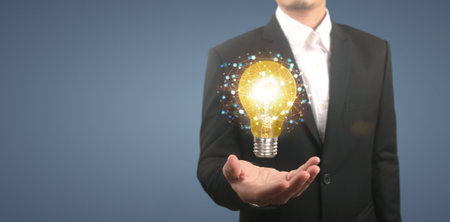 Hand of holding illuminated light bulb, idea, innovation inspiration conceptの写真素材