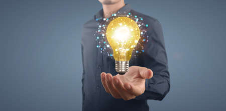 Hand of holding illuminated light bulb, idea, innovation inspiration conceptの写真素材